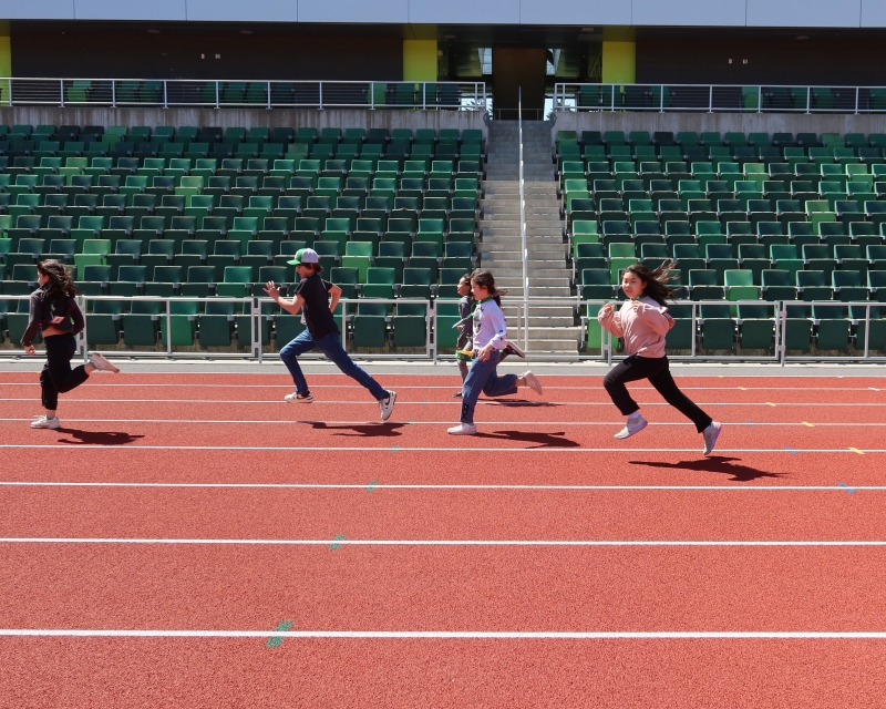 four children running on a track