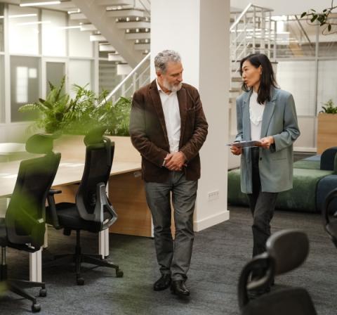 two people talking while walking through office